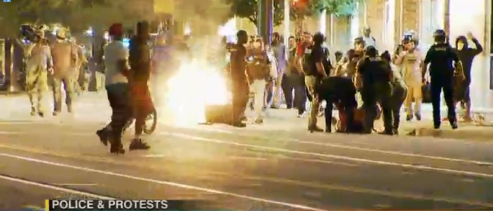 Demonstrators and rioters surround a fire in downtown Charlotte during riots in the city. [WCCB livestream screengrab]