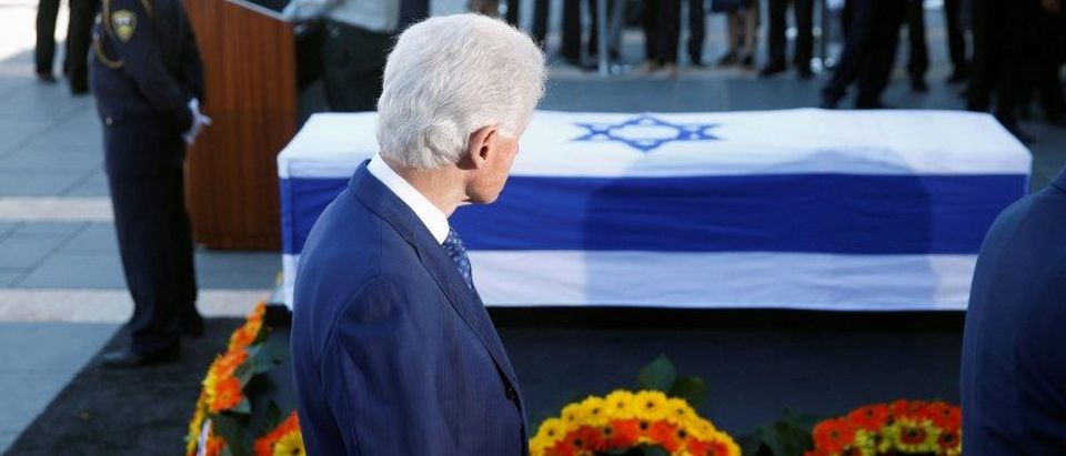 Former President Bill Clinton stands next to the flag-draped coffin of former Israeli President Shimon Peres, as he lies in state at the Knesset plaza, the Israeli parliament, in Jerusalem