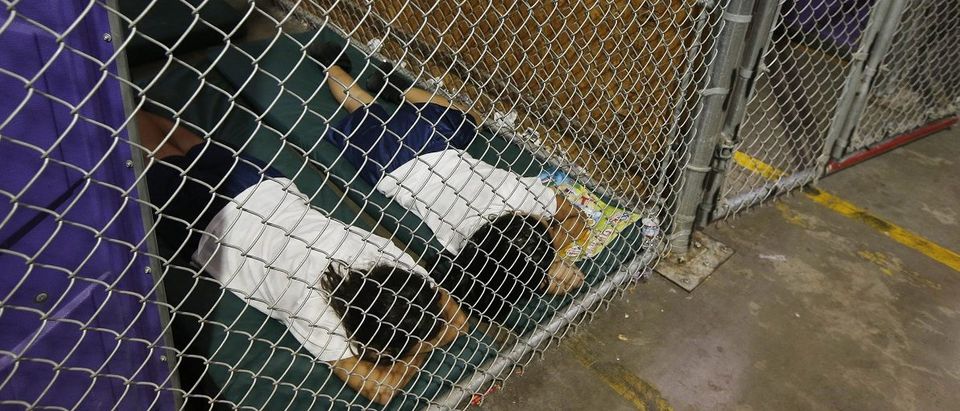 Two female detainees sleep in a holding cell as the children are separated by age group and gender at the U.S. Customs and Border Protection Nogales Placement Center in Nogales Arizona