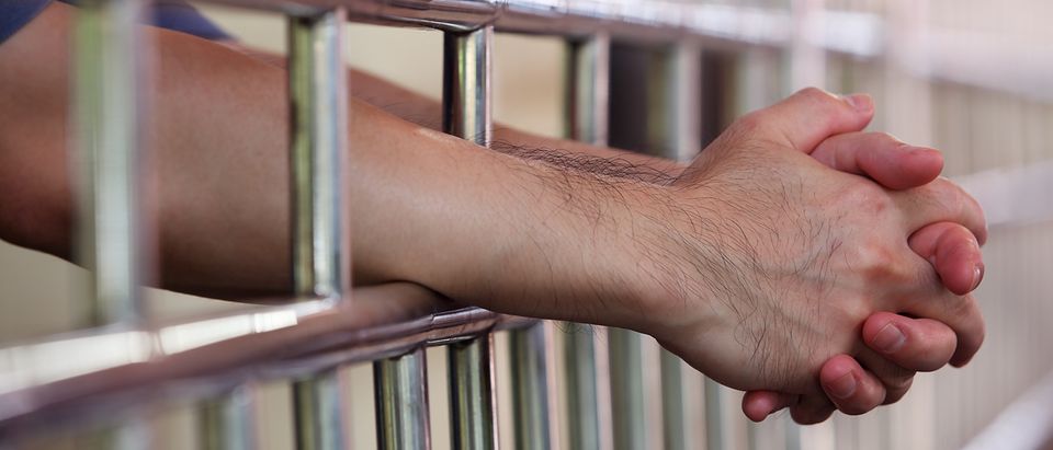 Man rests hands in prison