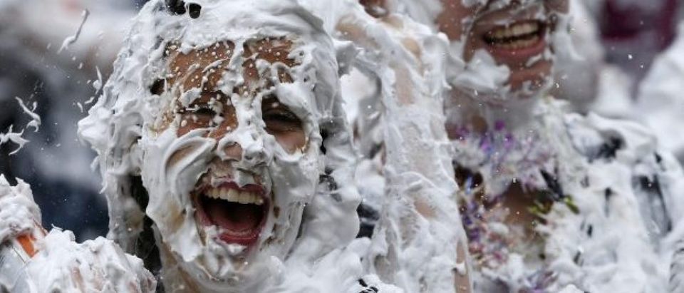 Students from St Andrews University are covered in foam as they take part in the traditional 'Raisin Weekend' in the Lower College Lawn, at St Andrews in Scotland
