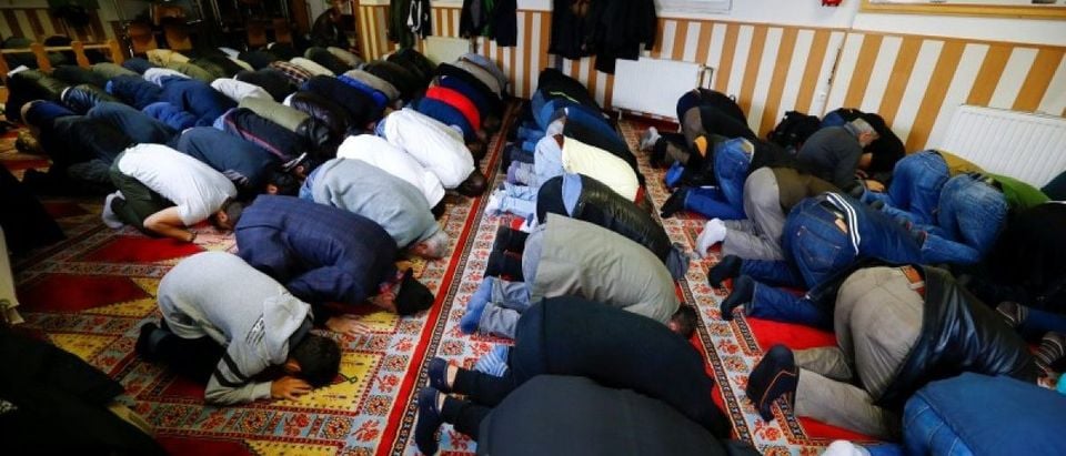 Muslims pray during Friday prayers at the Turkish Kuba Camii mosque located near a hotel housing refugees in Cologne's district of Kalk