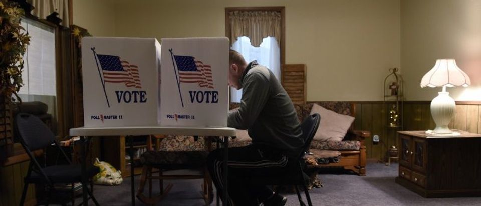A voter fills out his ballot in a living room polling place during the U.S. presidential election in Dover, Oklahoma