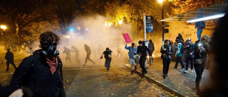 People try to move away from a gas cloud during a protest against the election of Republican Donald Trump as President of the United States in Portland, Oregon