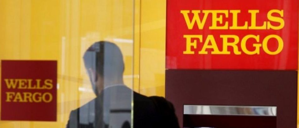 A man walks by a bank machine at the Wells Fargo &amp; Co. bank in downtown Denver