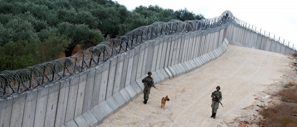 File picture of a K9 unit patrolling along a wall on the border line between Turkey and Syria, near the southeastern village of Besarslan in Hatay province