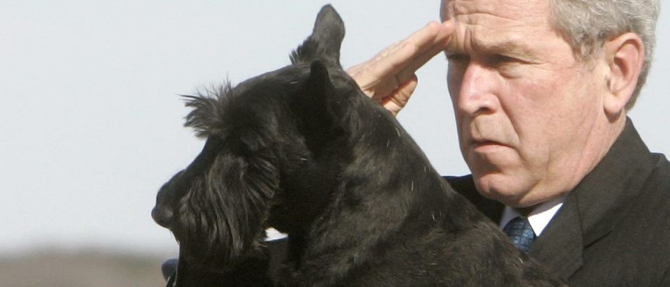 U.S. President George W. Bush holds his dog Barney and salutes while departing Air Force One at TSTC in Waco
