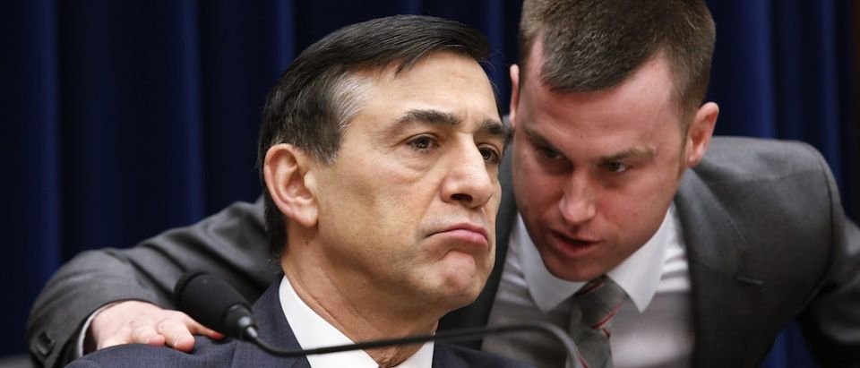 Chairman of the House Oversight and Government Reform Committee Rep. Issa listens to his staff member during the Committee hearing on "Examining the IRS Response to the Targeting Scandal" on Capitol Hill in Washington