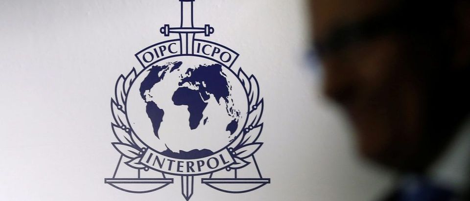 A man passes an Interpol logo during the handing over ceremony of the new premises for Interpol's Global Complex for Innovation in Singapore