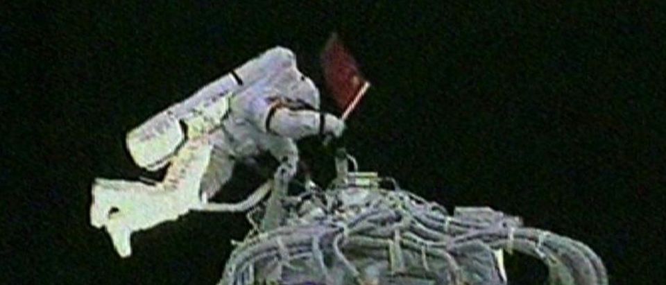 Video grab of astronaut Zhai Zhigang of China holding the national flag after exiting the Shenzhou VII space craft