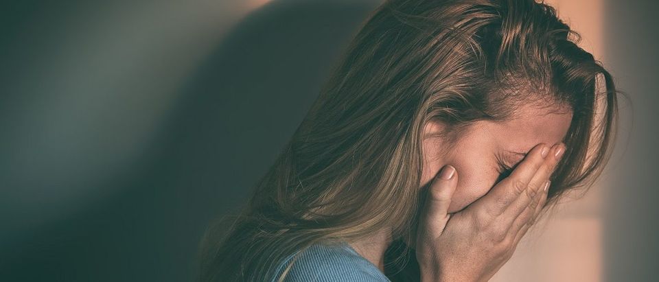 Suicidal woman cries alone. (Marjan Apostolovic/Shutterstock).
