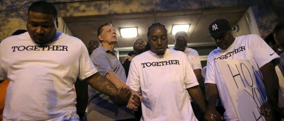 Father Michael Pfleger (2nd L) prays at Saint Sabina Church before taking part in a weekly night-time peace march through the streets of a South Side neighborhood in Chicago, Illinois, September 16, 2016. REUTERS/Jim Young