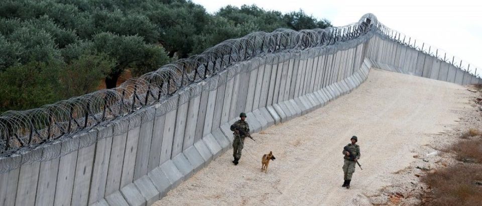 A K9 unit patrol along a wall on the border line between Turkey and Syria, near the southeastern village of Besarslan in Hatay province