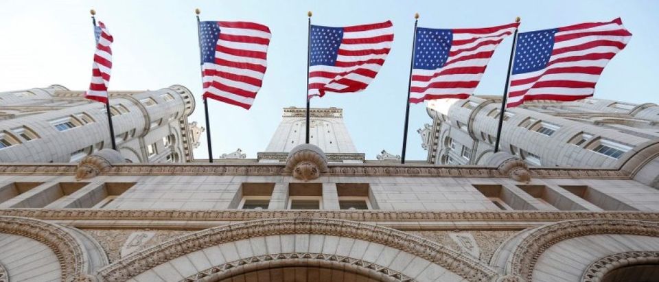 Flags fly above the entrance to the new Trump International Hotel on its opening day in Washington