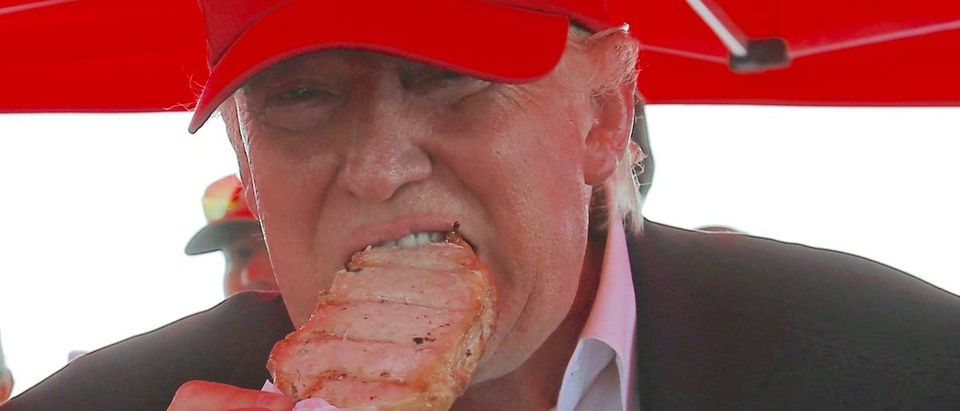 U.S. Republican presidential candidate Donald Trump eats a pork chop at the Iowa State Fair during a campaign stop in Des Moines