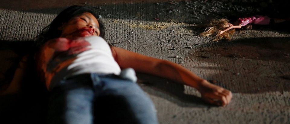 A 17 year old girl lays dead next to her doll after she and her friend were killed by unknown motorcycle-riding gunmen, in an alley in Manila