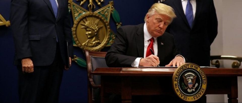 U.S. President Donald Trump signs an executive order he said would impose tighter vetting to prevent foreign terrorists from entering the United States at the Pentagon in Washington