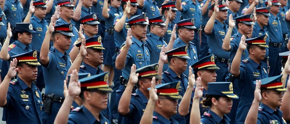 Police officers take their oath at the Philippine National Police headquarters in Quezon