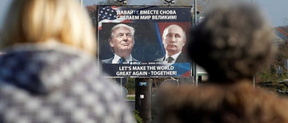 FILE PHOTO: A billboard showing a pictures of US president-elect Donald Trump and Russian President Vladimir Putin is seen through pedestrians in Danilovgrad