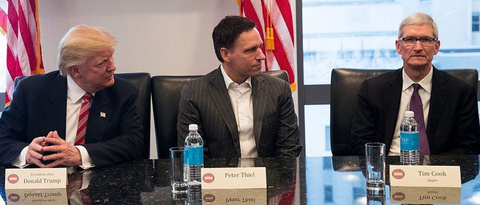 NEW YORK, NY - DECEMBER 14: (L to R) President-elect Donald Trump, Peter Thiel and Tim Cook, chief executive officer of Apple, Inc., listen during a meeting with technology executives at Trump Tower. (Photo by Drew Angerer/Getty Images)