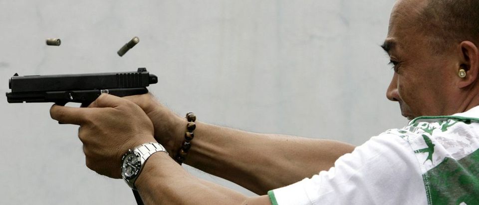 A policeman shoots at target at a firing range in Manila May 19, 2009. The Philippines, which has more gun-related deaths than any other country in Asia relative to its size, needs tougher gun control laws as the number of illegal weapons has topped one million, a police general said on Monday. REUTERS/Cheryl Ravelo