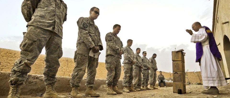 U.S. Army Capt. Carl Subler, right, a chaplain, delivers a Catholic mass to Soldiers from Alpha Company, 1st Battalion, 17th Infantry Regiment at an abandoned compound during Operation Moshtarak in Badula Qulp, Helmand province, Afghanistan, Feb. 21, 2010. (U.S. Air Force photo by Tech. Sgt. Efren Lopez/Released)
