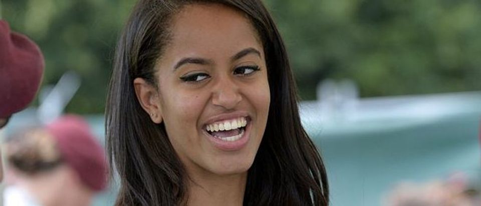 Malia Obama smiles as she serves food during a lunch at the United States and Nato military base in Vicenza on June 19, 2015. (Photo credit: ANDREAS SOLARO/AFP/Getty Images)