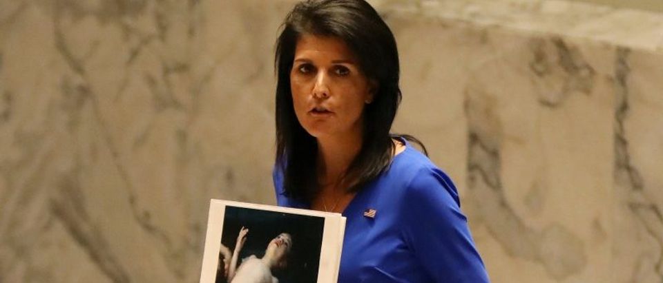U.S. Ambassador to the United Nations Nikki Haley holds photographs of victims during a meeting at the United Nations Security Council on Syria at the United Nations Headquarters in New York City