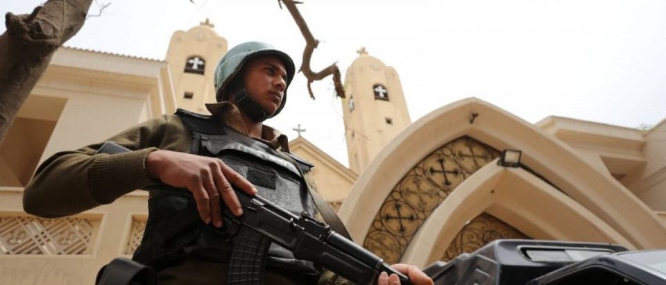 An armed policeman secures the Coptic church that was bombed on Sunday in Tanta