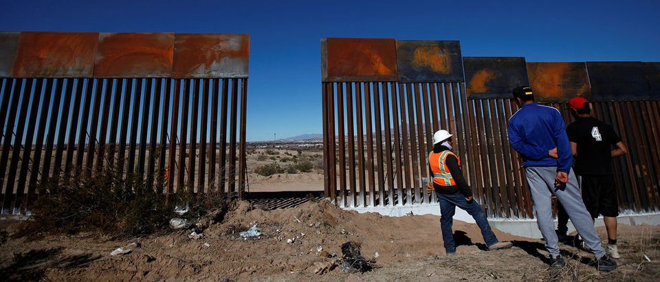 Worker chats with residents at a newly built section of the U.S.-Mexico border fence at Sunland Park, U.S. opposite the Mexican border city of Ciudad Juarez
