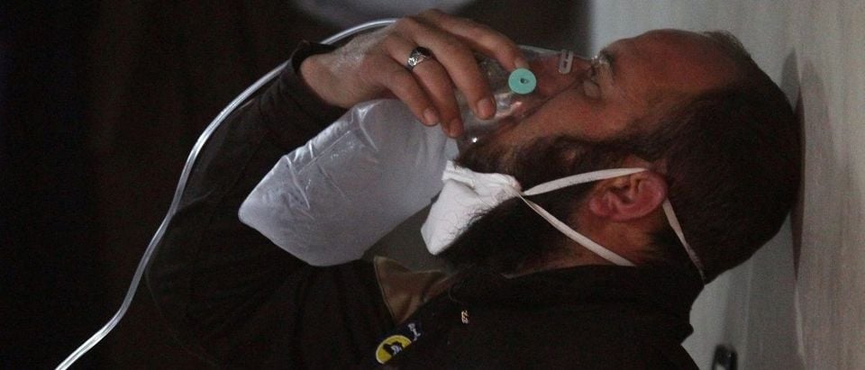A civil defence member breathes through an oxygen mask, after what rescue workers described as a suspected gas attack in the town of Khan Sheikhoun in rebel-held Idlib