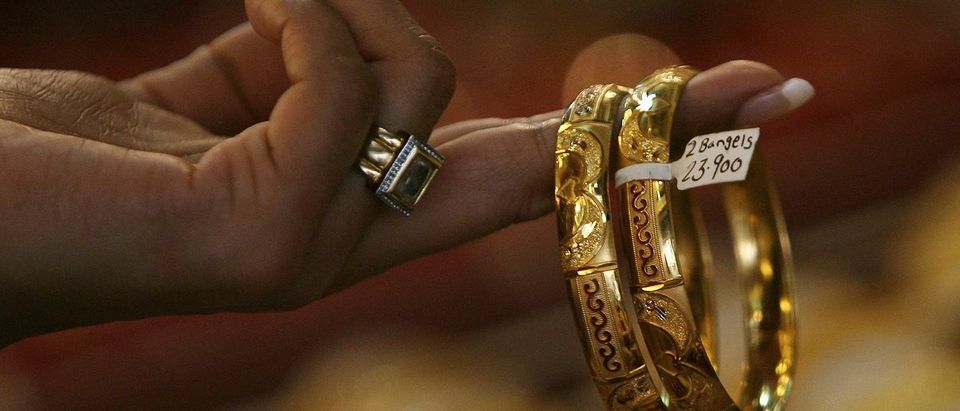 A female customer looks at gold bangles at a jewellery shop in Mumbai