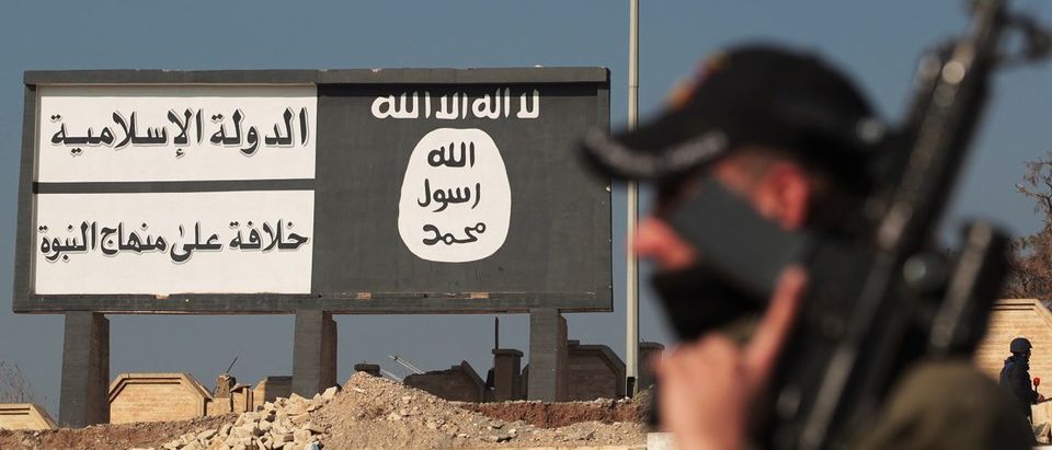A member of the special forces' Counter-Terrorism Service (CTS) stands in front of a billboard bearing the logo of the Islamic State (IS) group in Mosul's eastern district of Mohandessin on January 19, 2017, during an ongoing military operation against IS jihadists. Iraqi forces battled the last holdout jihadists in east Mosul after commanders declared victory there and set their sights on the city's west, where more tough fighting awaits. Ahmad Al-Rubaye/AFP/Getty Images.