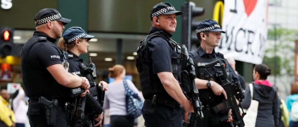 Armed police officers stand on duty in central Manchester