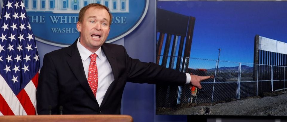 Director of the Office of Management and Budget Mick Mulvaney points to a picture of construction of the southern border while speaking about the budget agreement reached by Congress during a press briefing at the White House in Washington