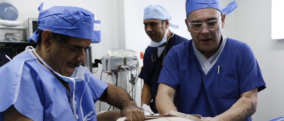 Doctors put a body corset on patient Maria Carolina Parejo after surgery (Picture taken October 30, 2013. REUTERS/Carlos Garcia Rawlins