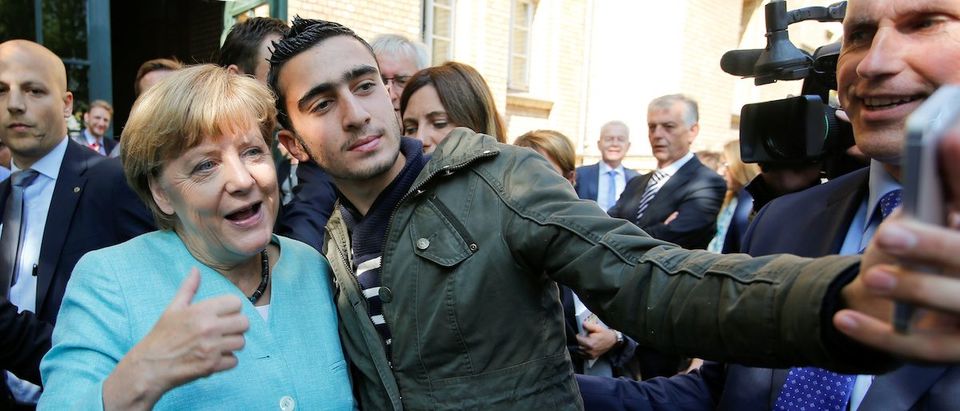 FILE PHOTO: Syrian refugee Anas Modamani takes a selfie with German Chancellor Angela Merkel outside a refugee camp near the Federal Office for Migration and Refugees after registration at Berlin's Spandau district, Germany September 10, 2015. A German court will on February 6, 2017 hold its first hearing in the case of a Syrian refugee who is suing Facebook after the social networking site declined to remove all posts linking him to crimes and militant attacks. REUTERS/Fabrizio Bensch/File Photo