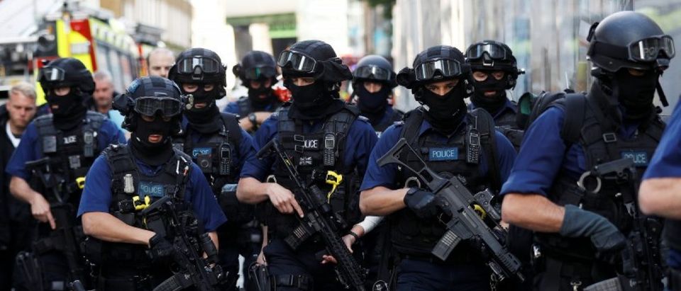 Armed police officers walk near Borough Market after an attack left 7 people dead and dozens injured in London