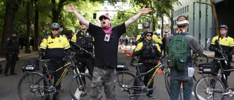 An anti-fascist protester shouts to others to join him at a police line during competing demonstrations in Portland, Oregon, U.S. June 4, 2017. REUTERS/Jim Urquhart