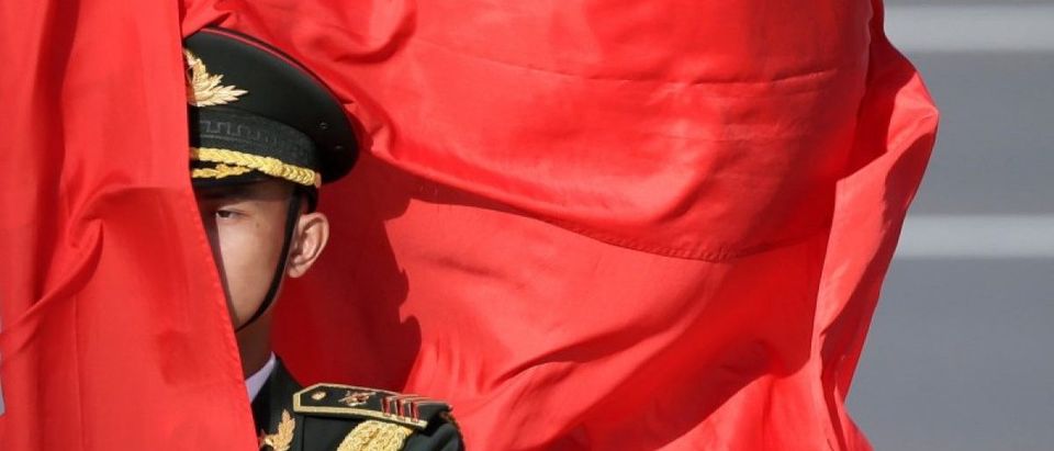 A soldier from honour guards holds a red flag during a welcoming ceremony in Beijing