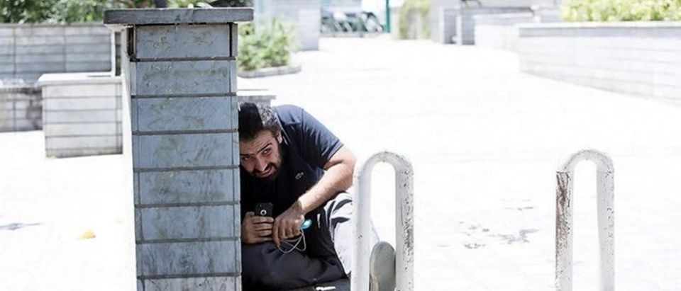 A man takes cover during an attack on the Iranian parliament in central Tehran