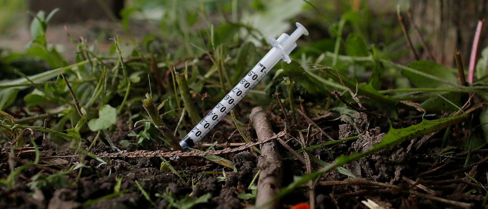 A used needle sits on the ground in a park in Lawrence, Massachusetts, U.S., May 30, 2017, where individuals were arrested earlier in the day during raids to break up heroin and fentanyl drug rings in the region, according to law enforcement officials. REUTERS/Brian Snyder