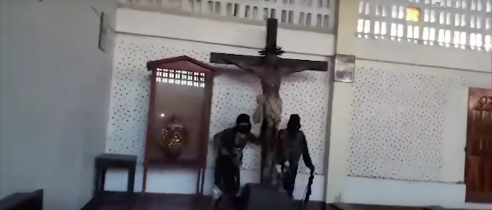 Two ISIS members destroy a crucifix in a Catholic church in the Philippines. Source: YouTube screen shot/Arjun R