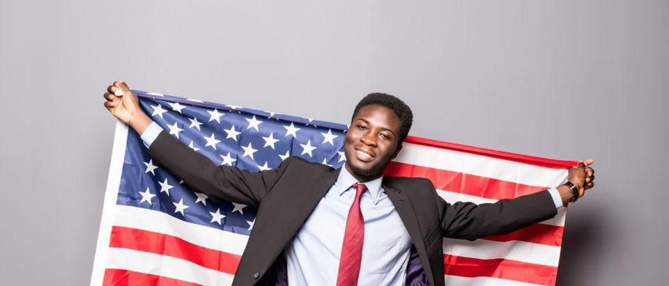 Black man with American flag (Shutterstock/F8 studio)