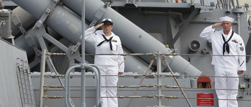 U.S. sailors salute in front of missile launchers onboard the USS Fitzgerald destroyer in Manila