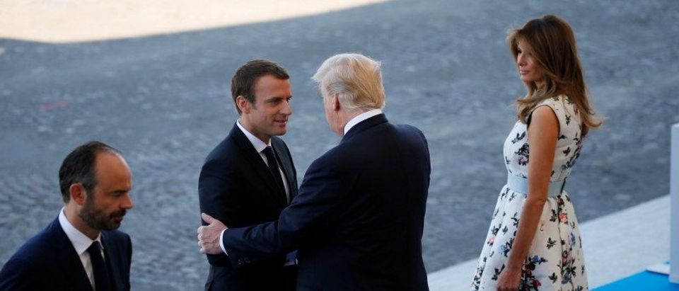French President Emmanuel Macron shakes hands with US President Donald Trump before the traditional Bastille Day military parade on the Champs-Elysees in Paris