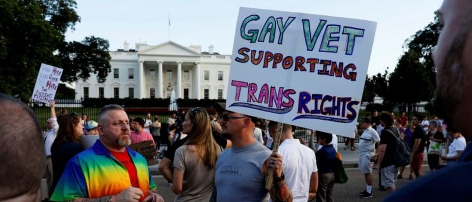 Demonstrators gather to protest Trump's announcement that he plans to reinstate a ban on transgender individuals from serving in the military, at the White House in Washington