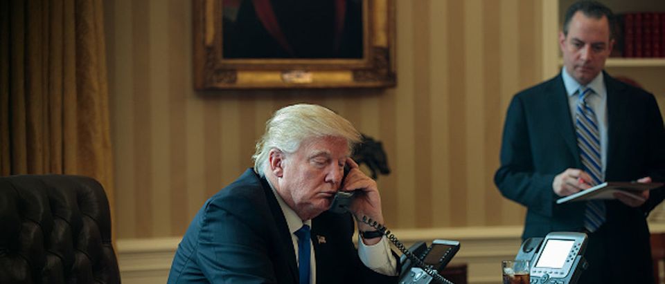 WASHINGTON, DC - JANUARY 28: White House Chief of Staff Reince Priebus (R) looks on as President Donald Trump speaks on the phone with Russian President Vladimir Putin in the Oval Office of the White House, January 28, 2017 in Washington, DC. On Saturday, President Trump is making several phone calls with world leaders from Japan, Germany, Russia, France and Australia. (Photo by Drew Angerer/Getty Images)