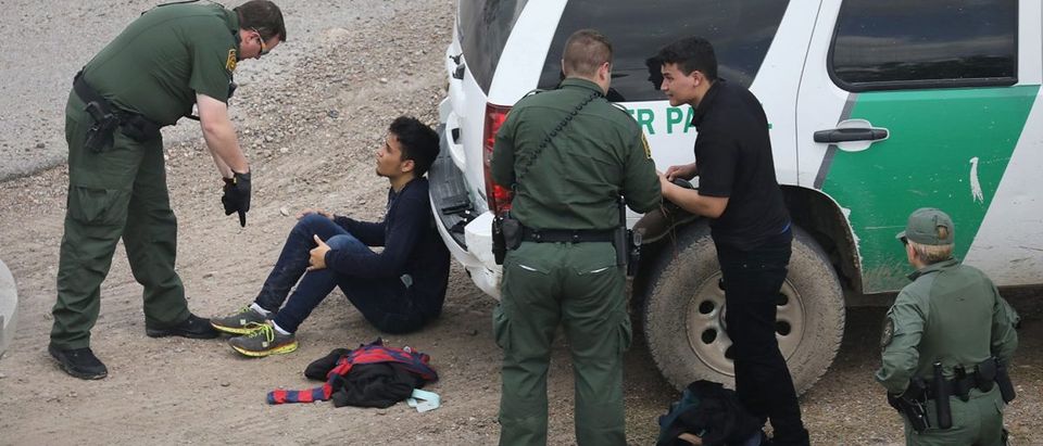 U.S. Border Patrol agents detain two undocumented immigrants after capturing them near the U.S.-Mexico border on March 15, 2017 near McAllen, Texas. U.S. Customs and Border Protection announced that illegal crossings along the southwest border with Mexico dropped 40 percent during the month of February. (Photo by John Moore/Getty Images)