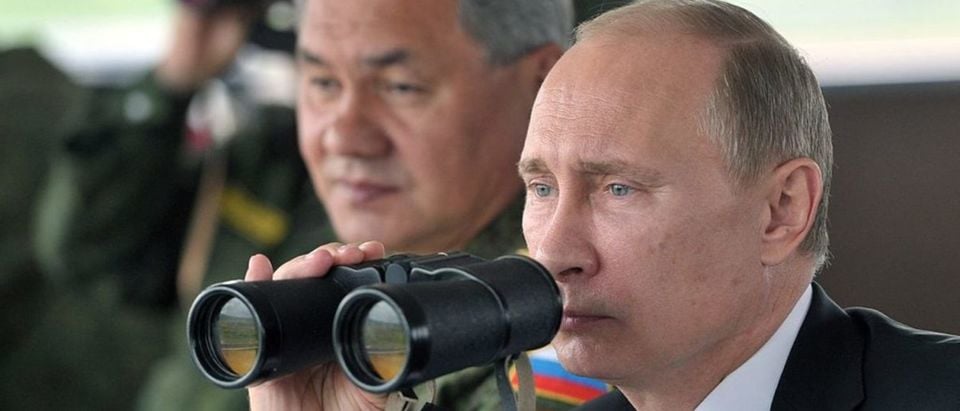 Russian President Vladimir Putin (R) and Defence minister Sergei Shoigu (L) inspect military exercises in the Pacific Ocean near the Sakhalin island on July 16, 2013. (Photo: ALEXEI NIKOLSKY/AFP/Getty Images)